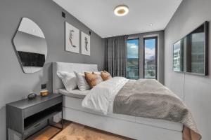 a bedroom with a bed with a mirror and a window at Penthouse in Downtown Tromsø NEW in Tromsø