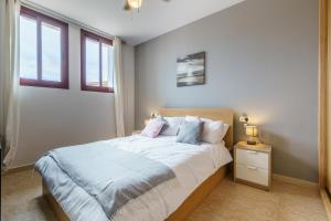 a bedroom with a large bed and two windows at CT 138 - La Cala Boulevard - Apartement I in La Cala de Mijas