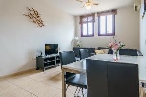 a living room with a table and chairs and a tv at CT 138 - La Cala Boulevard - Apartement I in La Cala de Mijas +11 photos