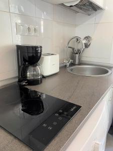 blat kuchenny z ekspresem do kawy i zlewem w obiekcie Acogedor apartamento exterior con balcón en el Barrio de Chueca, Gran Vía con aire acondicionado w Madrycie