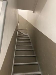 a stair case in a building with a ladder at Bienvenue dans le centre ville d’Amiens in Amiens