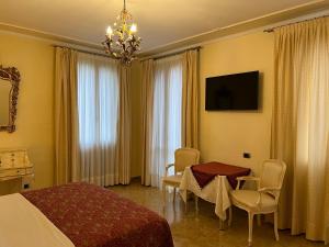 ヴェネツィアにあるInn Veniceのベッド、テーブル、椅子が備わるホテルルームです。