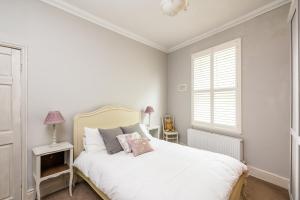 a white bedroom with a bed and a window at Pass the Keys Quaint 2 Bed within City Walls in York