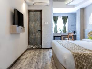 Schlafzimmer mit einem Bett, einem TV und einem Schreibtisch in der Unterkunft Vastu Boutique Hotel in Kathmandu
