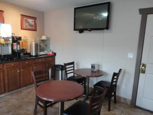 a kitchen with a table and chairs and a tv at Canadas Best Value Inn & Suites-Vernon in Vernon