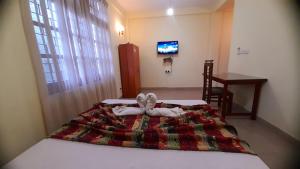 a bedroom with a bed with towels on it at Madara Hotel in Horana