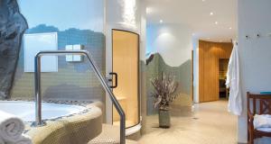 a bathroom with a bath tub in a room at Victor's Residenz-Hotel Frankenthal in Frankenthal