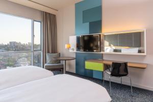 a hotel room with two beds and a desk and a window at Radisson Blu Hotel & Residence Maputo in Maputo