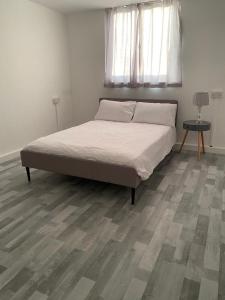 a bed in a bedroom with a wooden floor at Suites by Rehoboth - Overcomers- Deptford in London