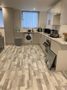 a kitchen with a washer and dryer in a room at Suites by Rehoboth - Overcomers- Deptford in London