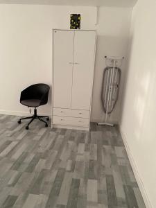 an empty room with a chair and a cabinet at Suites by Rehoboth - Overcomers- Deptford in London
