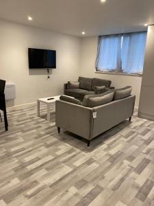 a living room with a couch and a flat screen tv at Suites by Rehoboth - Overcomers- Deptford in London