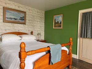 a bedroom with a wooden bed and green walls at La Maison du Passeur in Availles-Limouzine