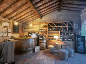 a wine tasting room with a bar and barrels at IL COLOMBAIO Winery in Monteriggioni