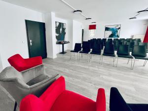 una sala de espera con sillas rojas y azules. en DORMERO Hotel Hoyerswerda, en Hoyerswerda