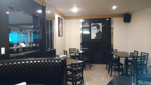 a dining room with tables and chairs with a picture on the wall at Hotel Frontiere Tijuana in Tijuana