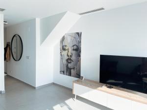 a living room with a flat screen tv and a wall at Casa 34 in Guardamar del Segura