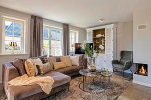 a living room with a couch and a fireplace at Ferienhaus SylterLiebe in Tinnum