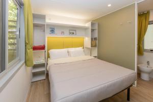 1 dormitorio con cama, lavabo y ventana en hu Montescudaio Village, en Montescudaio