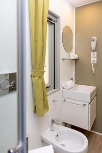 baño con cortina de ducha amarilla y lavamanos en hu Montescudaio Village, en Montescudaio