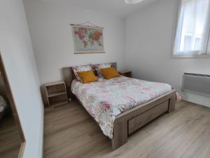 a small bedroom with a bed with two yellow pillows at Besançon appartement T2 sur cour intérieure proximité gare in Besançon