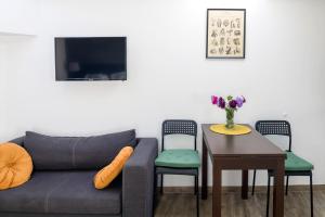 un soggiorno con un divano e un tavolo con sedie di Modern aparment in the very central location 19 a Cracovia