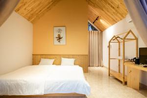 a bedroom with a white bed and a desk at LaVa Haus Homestay Hòa Bình - Venuestay in Hòa Bình