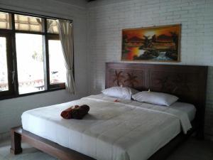 烏布的住宿－Rice paddy bungalow，卧室配有一张大白色床,位于带窗户的房间内