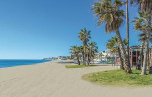 una playa de arena con palmeras y el océano en CT 143 - La Cala Boulevard - Apartement II en La Cala de Mijas