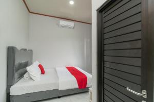 a bedroom with a bed next to a door at RedDoorz Plus near Jungeland Sentul in Bogor