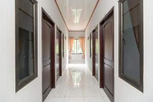 pasillo con puertas y suelo de baldosa en RedDoorz Plus near Jungeland Sentul, en Bogor