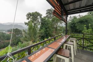een balkon met banken en uitzicht op het bos bij RedDoorz Plus near Jungeland Sentul in Bogor