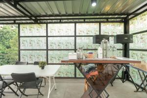 a screened in porch with a table and chairs at RedDoorz Plus near Jungeland Sentul in Bogor