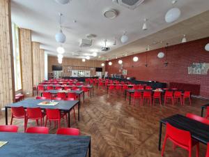 a dining room with tables and red chairs at Kääriku Hostel in Otepää
