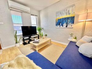 sala de estar con sofá azul y TV en Tastefully renovated - 3 bedroom apartment, en South Hedland