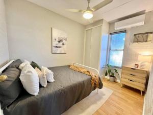 1 dormitorio con 1 cama, vestidor y ventana en Tastefully renovated - 3 bedroom apartment, en South Hedland