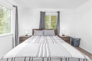 1 dormitorio con 1 cama grande y 2 ventanas en AlohAlaska Upstairs Suite, en Girdwood