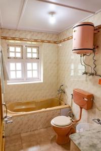 een badkamer met een toilet en een bad bij JOGINI HIGH MOUNT VILLA in Manāli