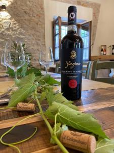 una bottiglia di vino seduta sopra un tavolo di legno di IL COLOMBAIO WINERY & Rooms a Monteriggioni