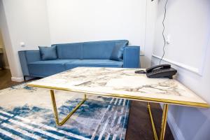 uma mesa de centro numa sala de estar com um sofá azul em El-Tau em Ekibastuz