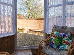 a room with a chair and a window with a view at The Little House in Briston