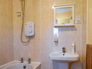 a bathroom with a sink and a toilet and a mirror at The Little House in Briston