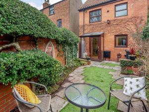 a small garden with chairs and a table and a patio at Strugglers Retreat - Uk32878 in Lincoln