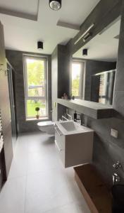 La salle de bains est pourvue d'un lavabo, de toilettes et d'une fenêtre. dans l'établissement Keller Apart K12 - Taras z widokiem na wyłączność i klimatyzacją GRATIS, à Porąbka