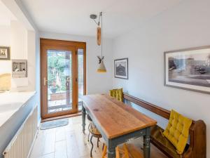a dining room with a wooden table and yellow chairs at Strugglers Retreat - Uk32878 in Lincoln