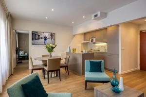 a living room with a table and chairs and a kitchen at Citadines Toison d’Or Brussels Aparthotel in Brussels