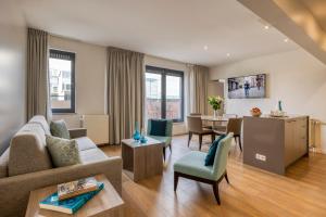 ein Wohnzimmer mit einem Sofa und einem Tisch in der Unterkunft Citadines Toison d’Or Brussels Aparthotel in Brüssel