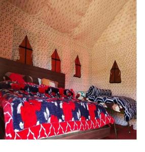 a bedroom with two beds with colorful blankets and pillows at Camping at Serene Chopta in Sari