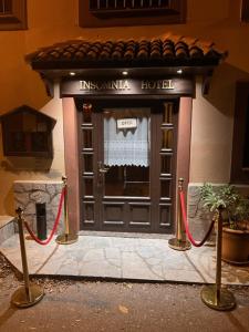 una puerta delantera de una casa con dos mangueras rojas en Insomnia Hotel en Berga