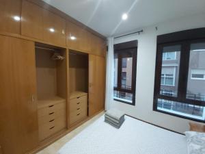 a bedroom with wooden cabinets and a bed and a window at Apartamento Ideal Retiro - Centro de Madrid in Madrid
